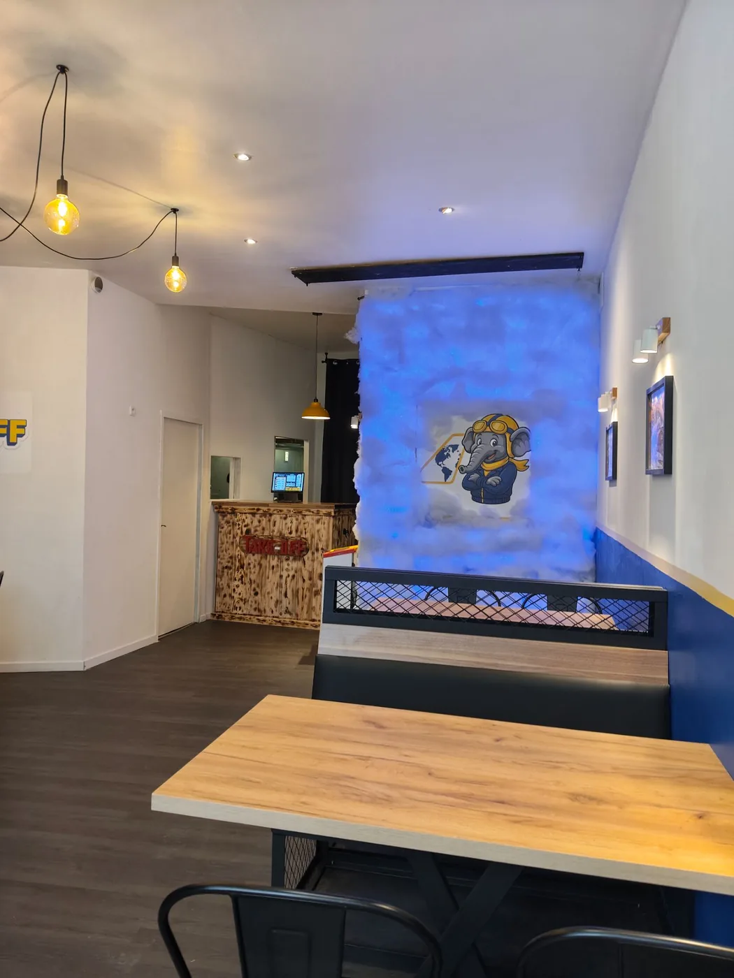 Salle de TAKE OFF avec comptoir bois et mur nuage